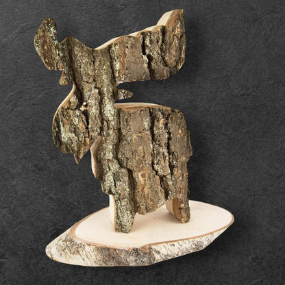 En dekorativ älg av al på en rustik träskiva med bark